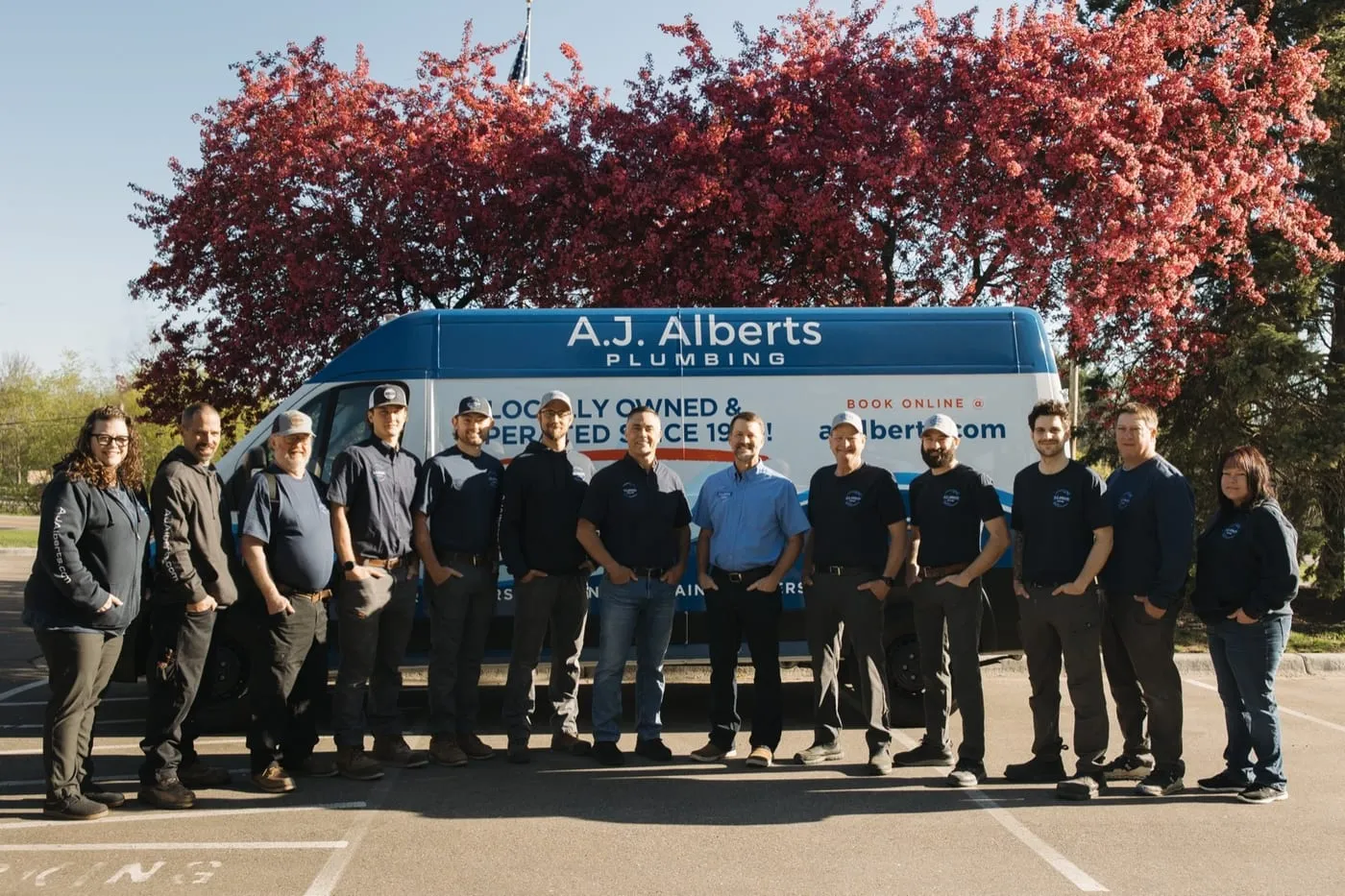 The full A.J. Alberts Plumbing team standing in front of a company service van, locally owned and operated in Woodbury